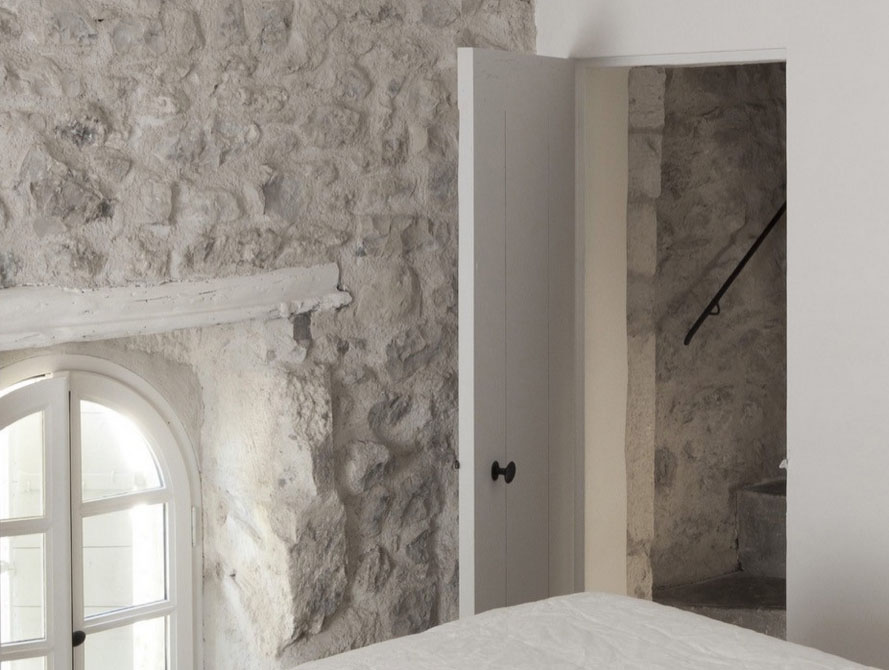 chambre provençale avec mur en pierres porte en bois rampe en fer